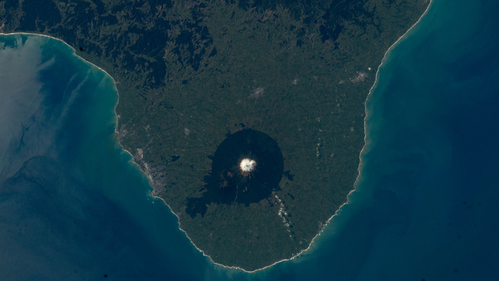 Photo taken from the International Space Station of Taranaki which clearly shows the National Park ring around the mountain.
