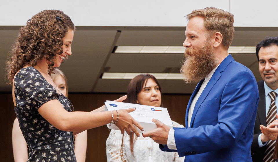 JJW presenting a flag and certificate to one of the students.